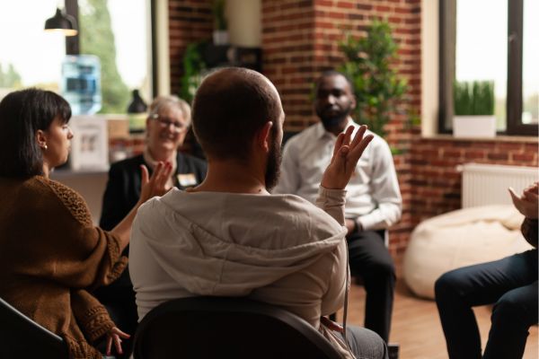 a group of individuals discussing the 12 principles of alcoholics anonymous.